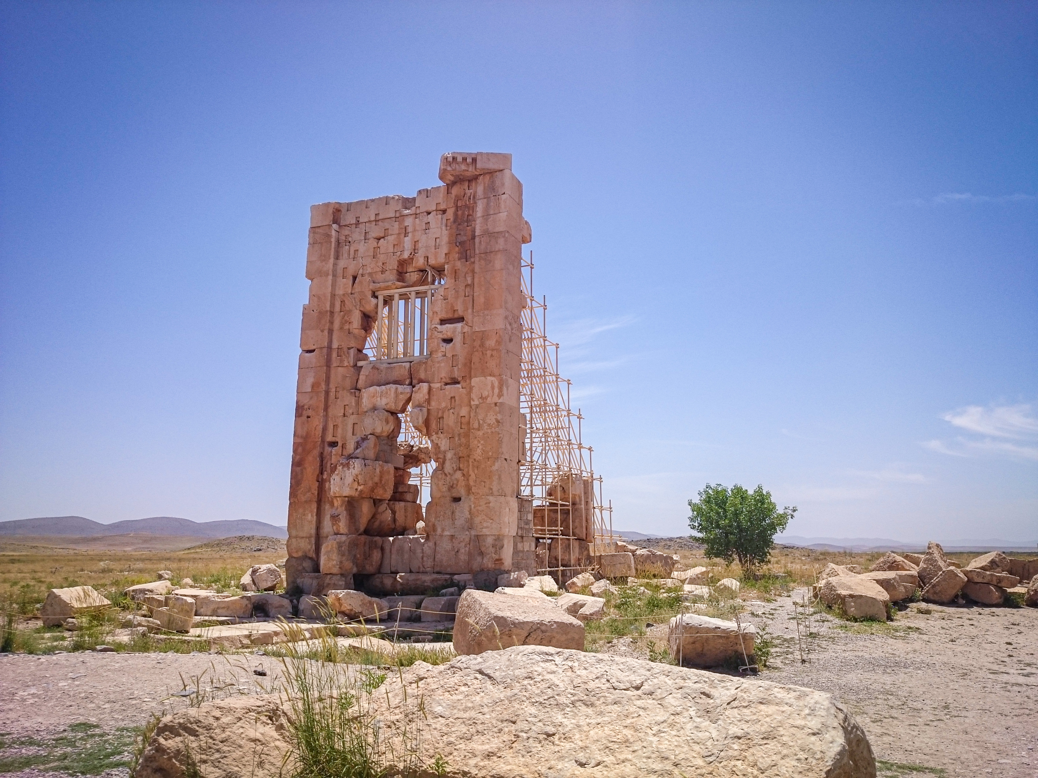 Stone Tower of Pasargadae, ancient Achaemenid structure with a single remaining wall and intricate stone masonry.