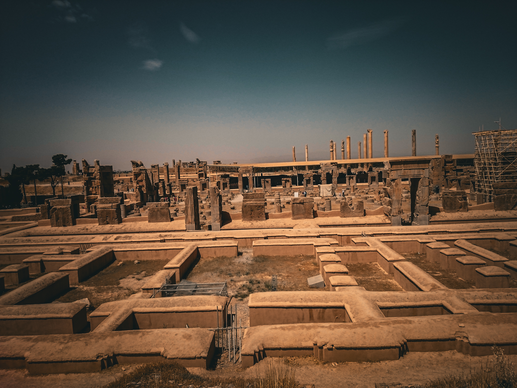 A view into a deep, rock-cut ancient wastewater and drainage channel at Persepolis, showcasing the sophisticated engineering of the Achaemenid Empire.